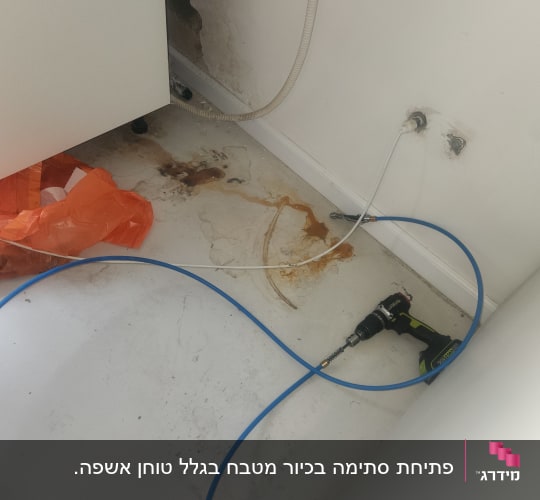 כלי עבודה וצינור ליד קיר עם כתמי רטיבות